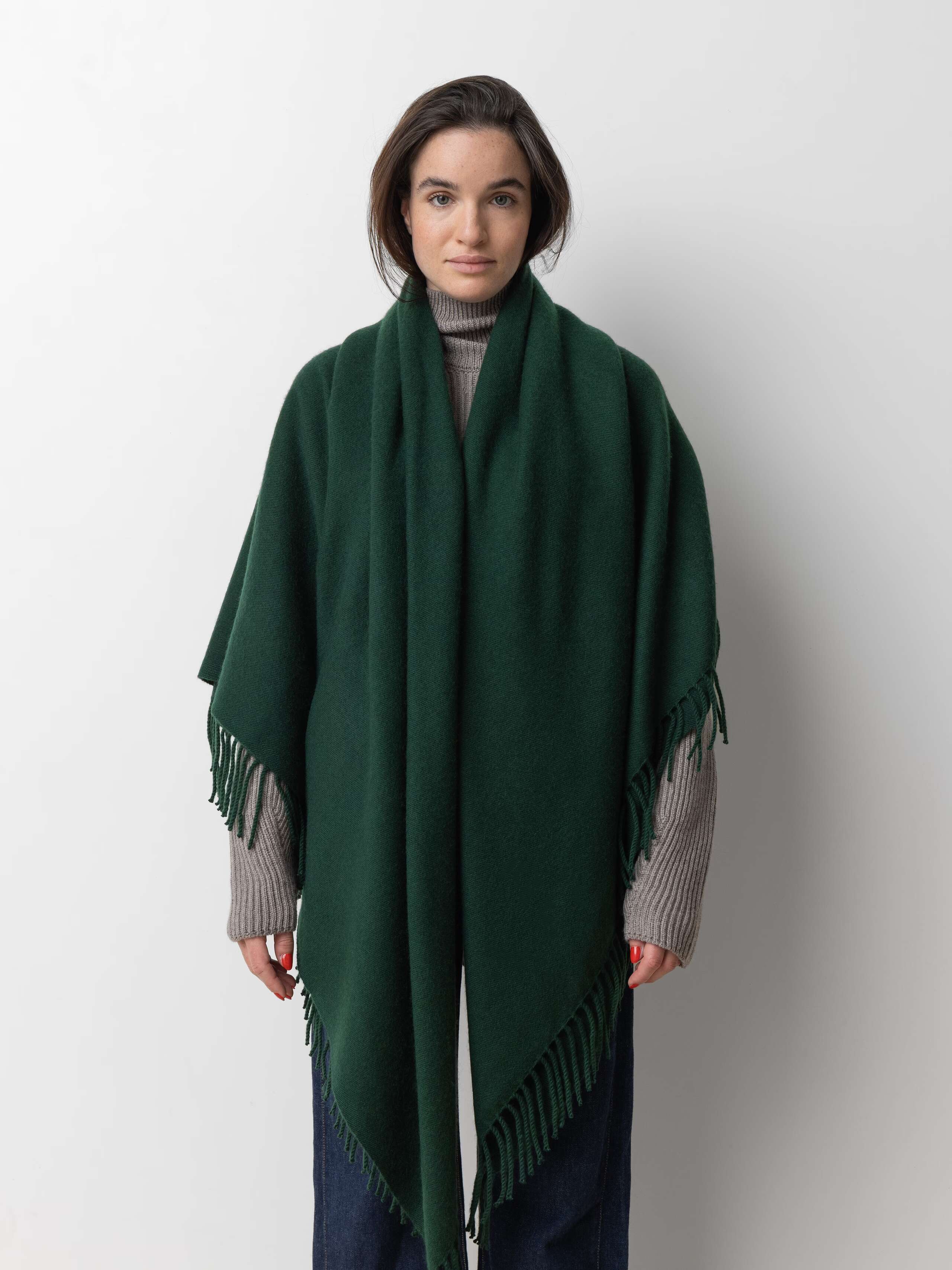 Picture of a female model wearing a jeans and a grey wool sweater and a green cashmere stole