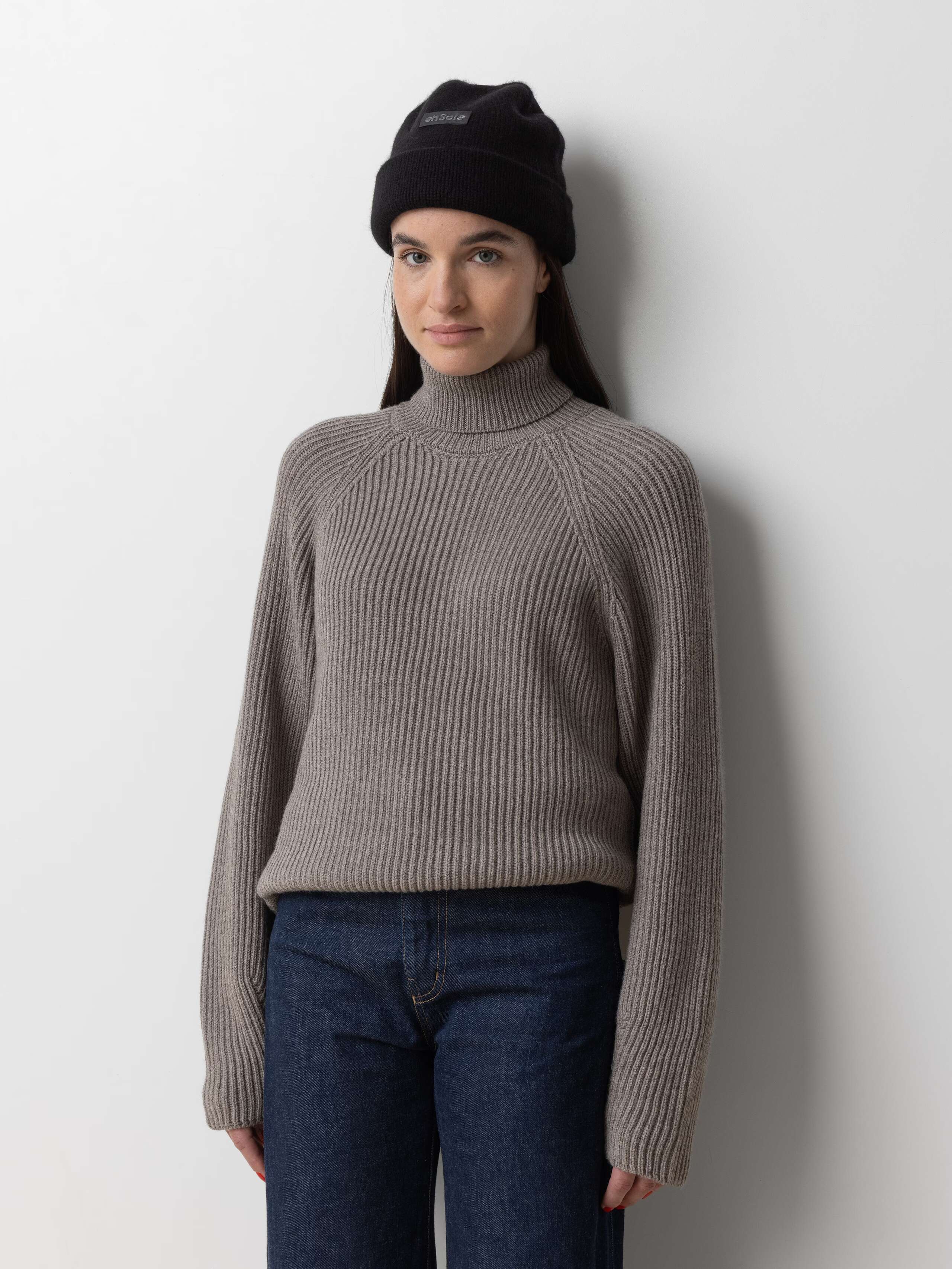 Picture of a female model wearing a black cashmere beanie