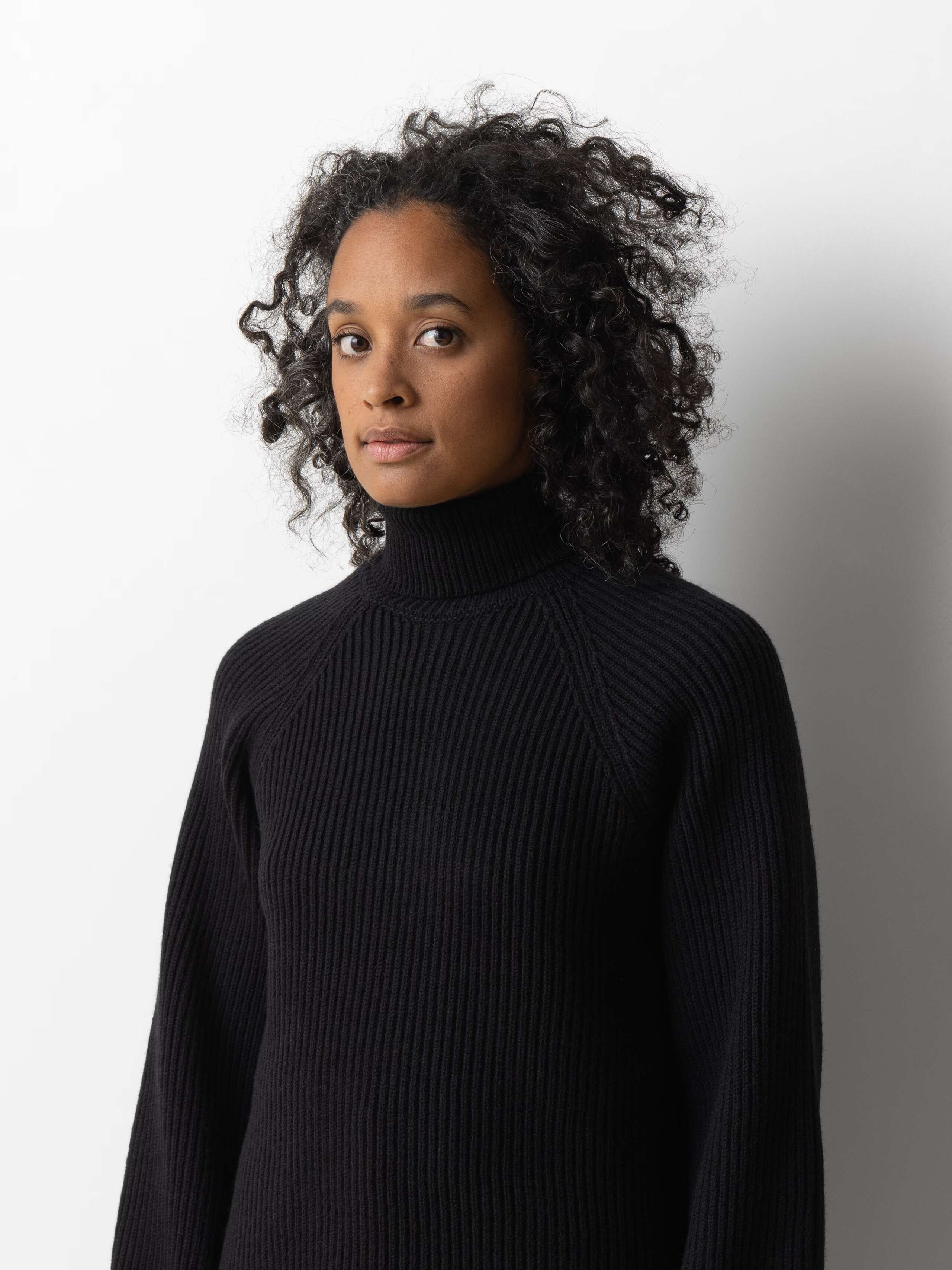 Picture of a female model wearing a beautiful black grey merino wool sweater 