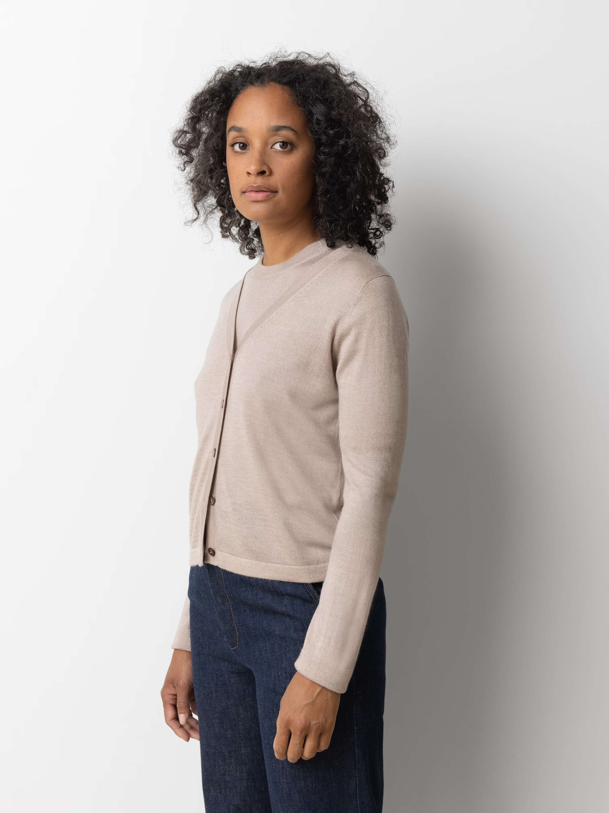 Picture of a female model wearing a beige cashmere shirt in combination with a beige cashmere cardigan
