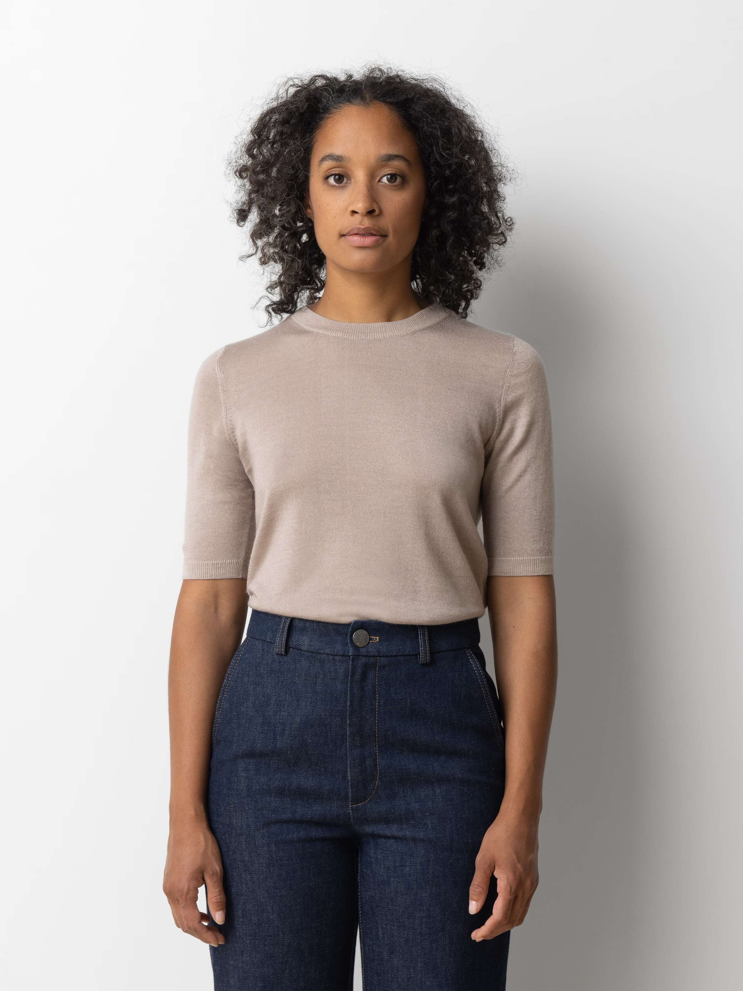 Picture of a female model wearing a beige cashmere shirt