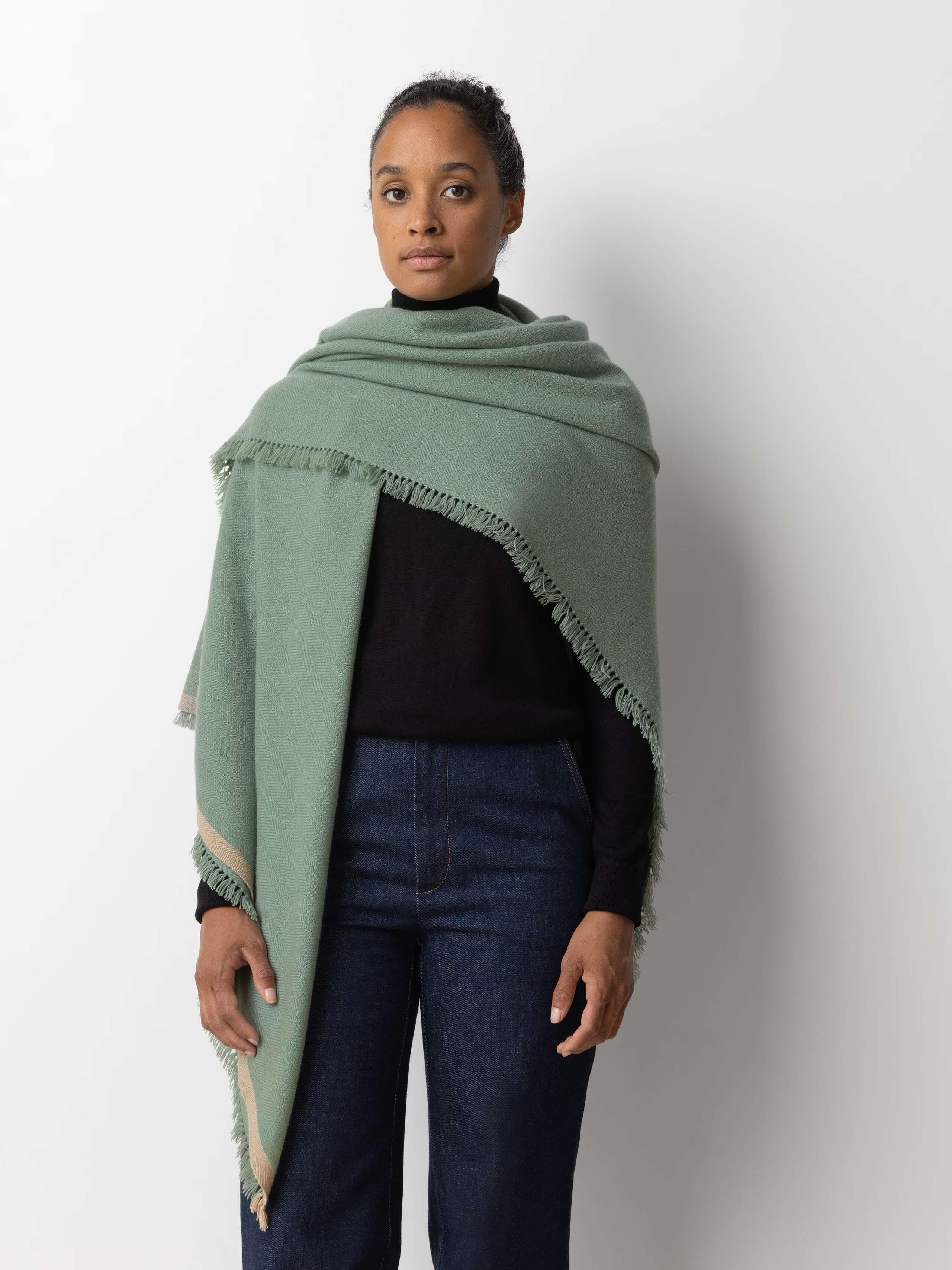 Picture of a female model wearing a cashmere stole in a light green blue shade