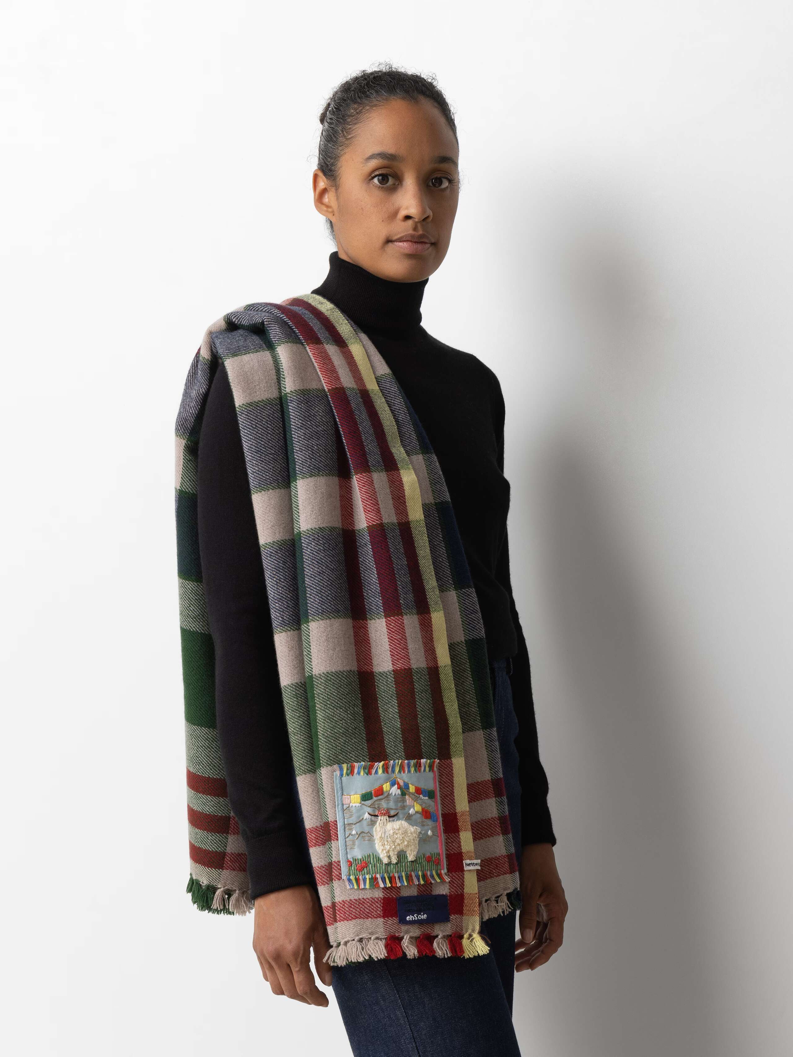 Picture of a female model wearing a black turtleneck in combination with a colourful cashmere stole