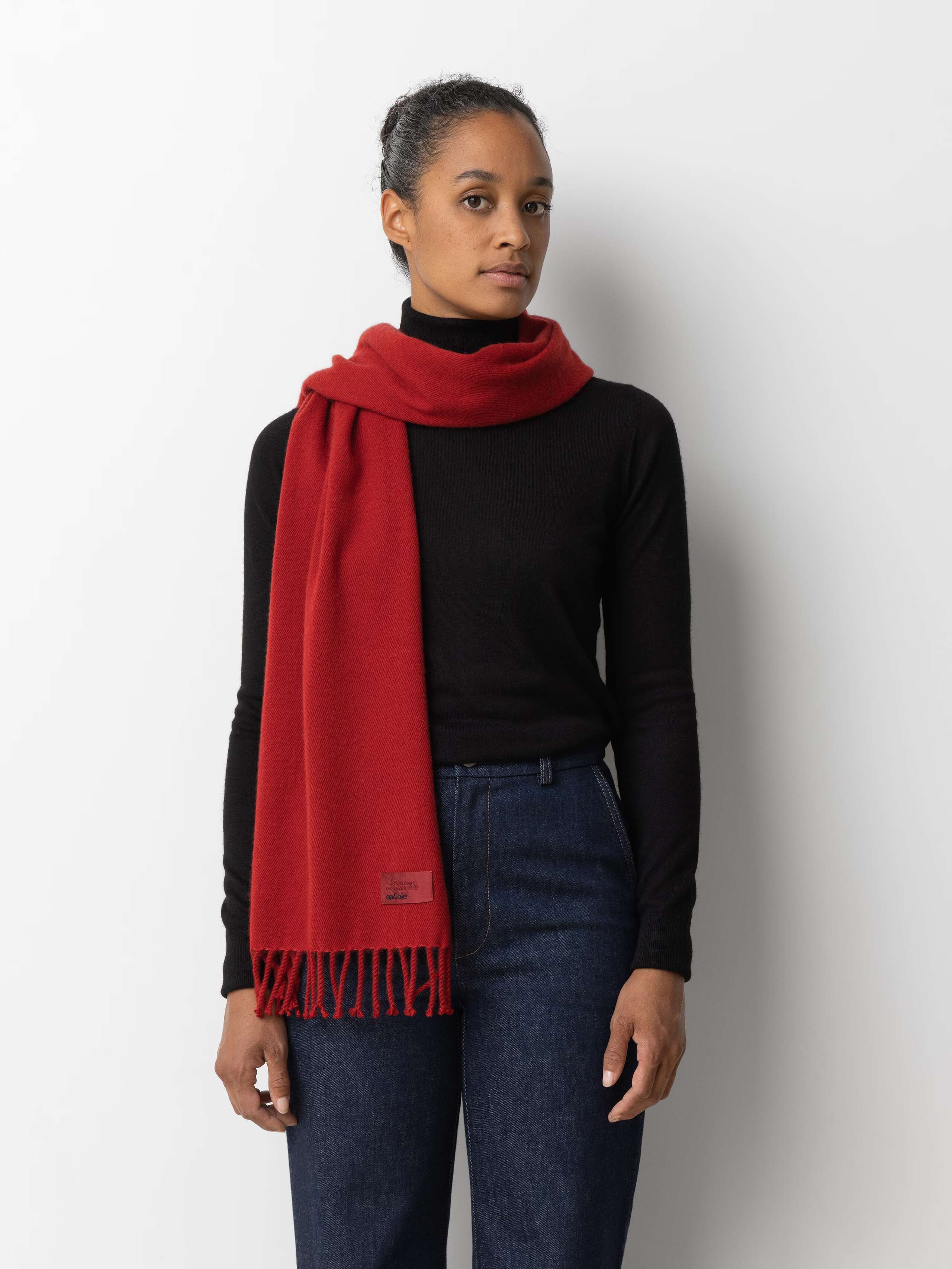 Picture of a female model wearing a black turtleneck in combination with a red cashmere scarf