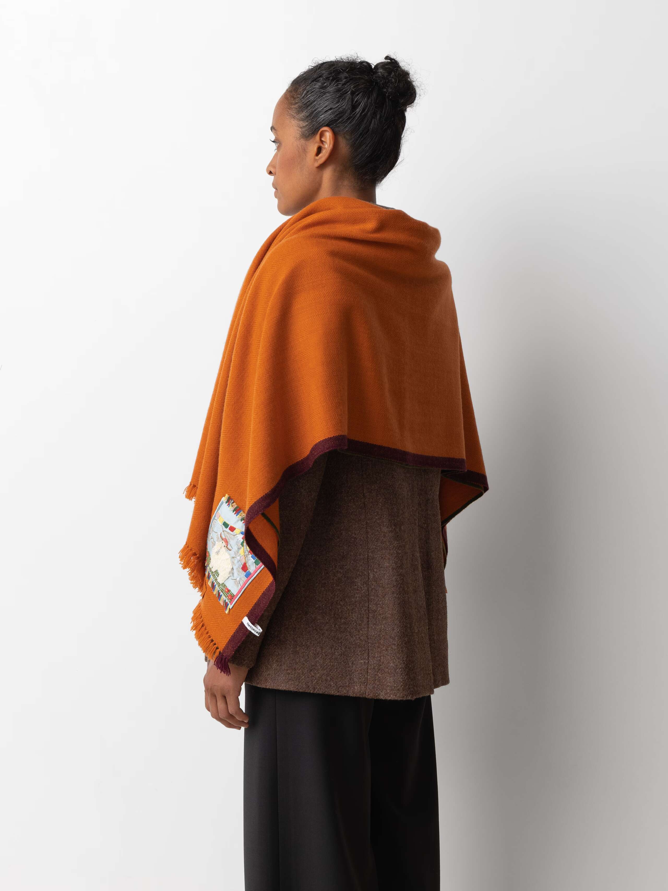 Picture of a female model wearing an orange cashmere stole