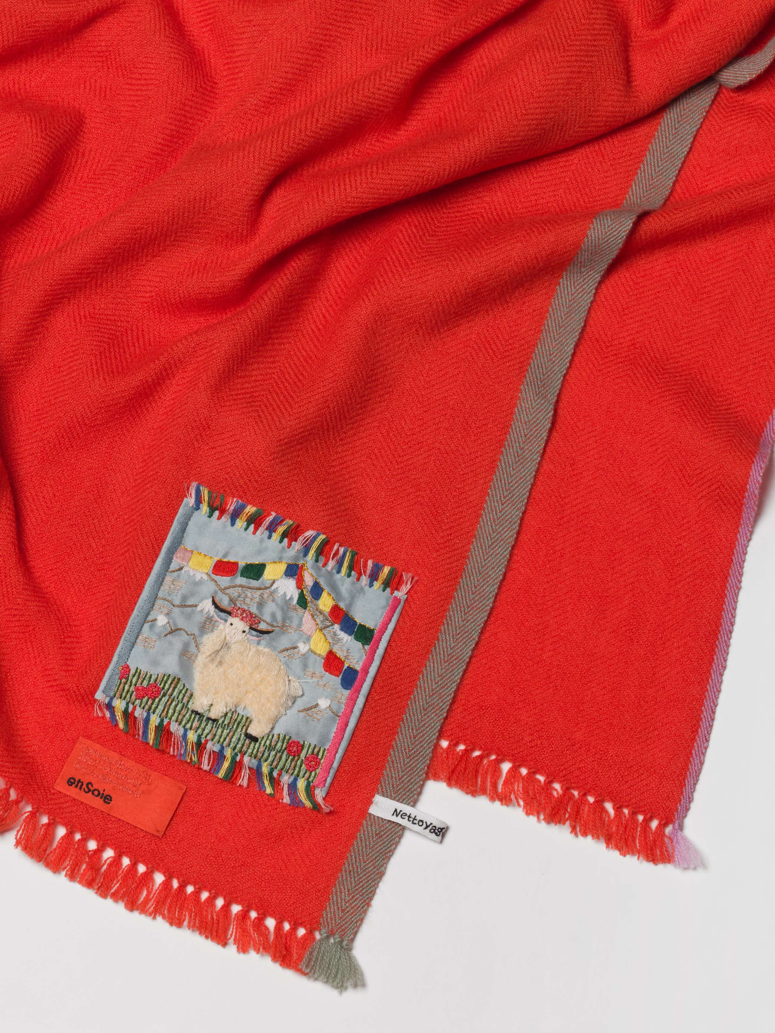 Picture of a female model wearing a bright red cashmere scarf