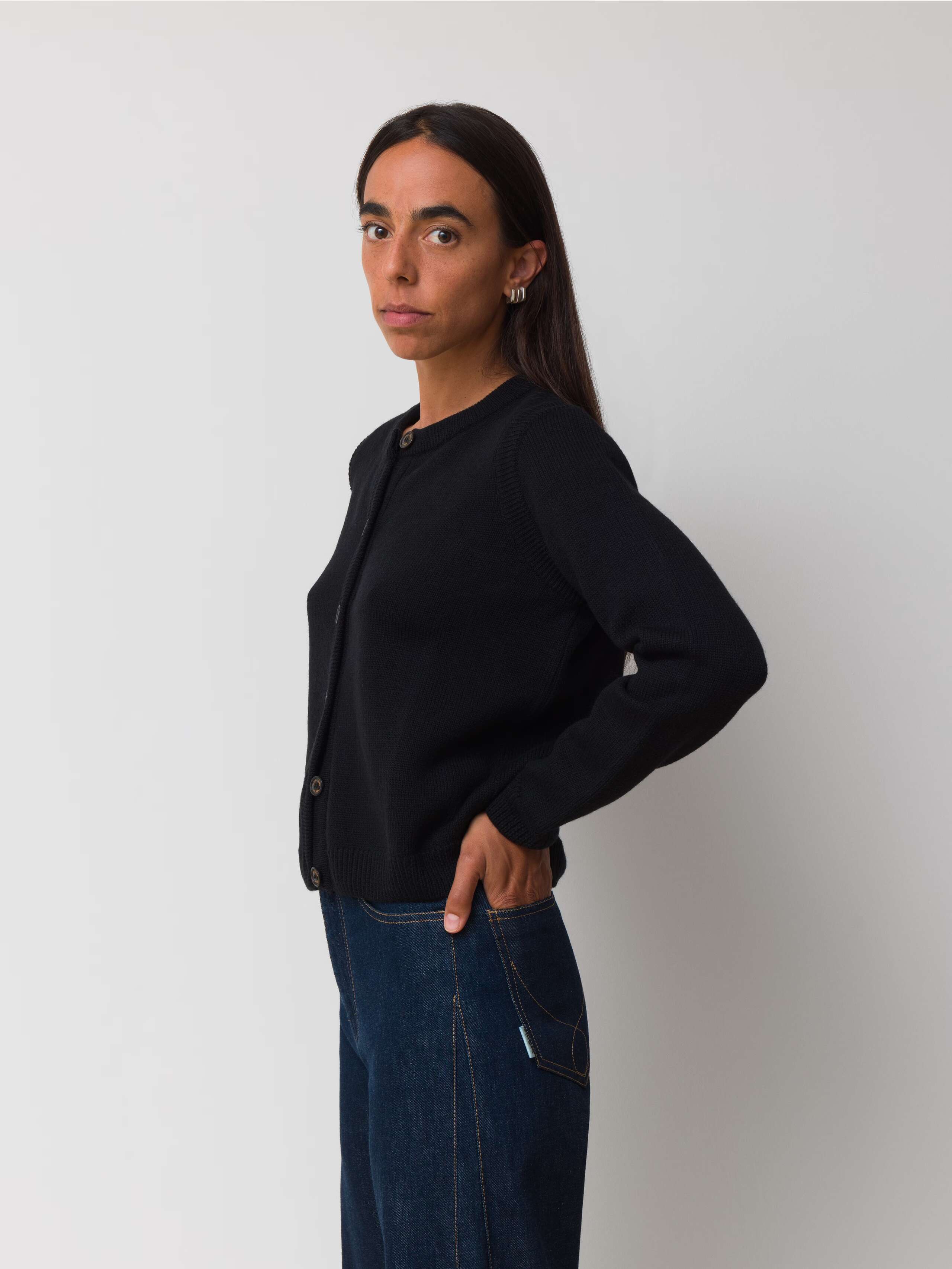 Female model is wearing a black merino wool cardigan