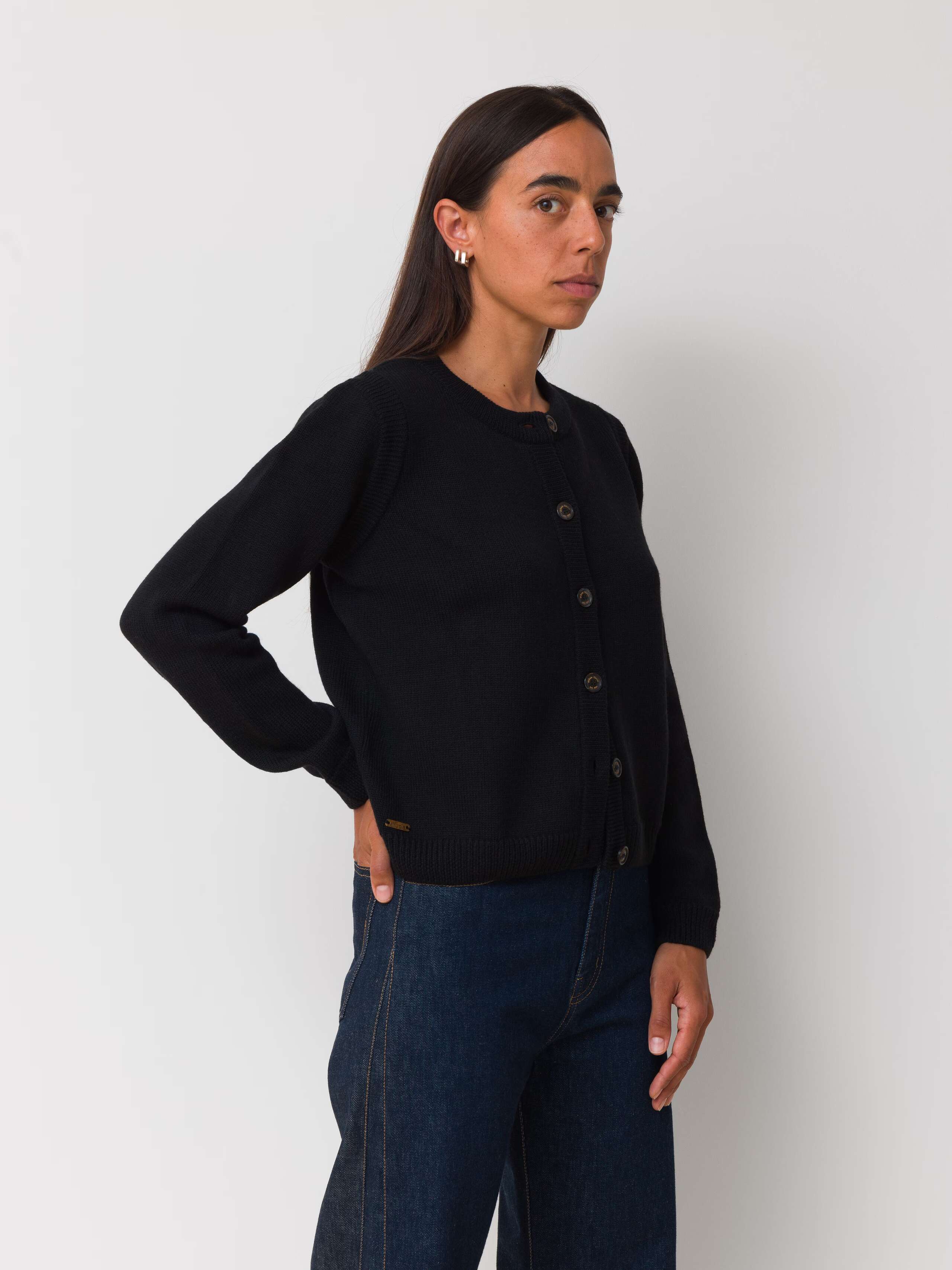 Female model is wearing a black merino wool cardigan