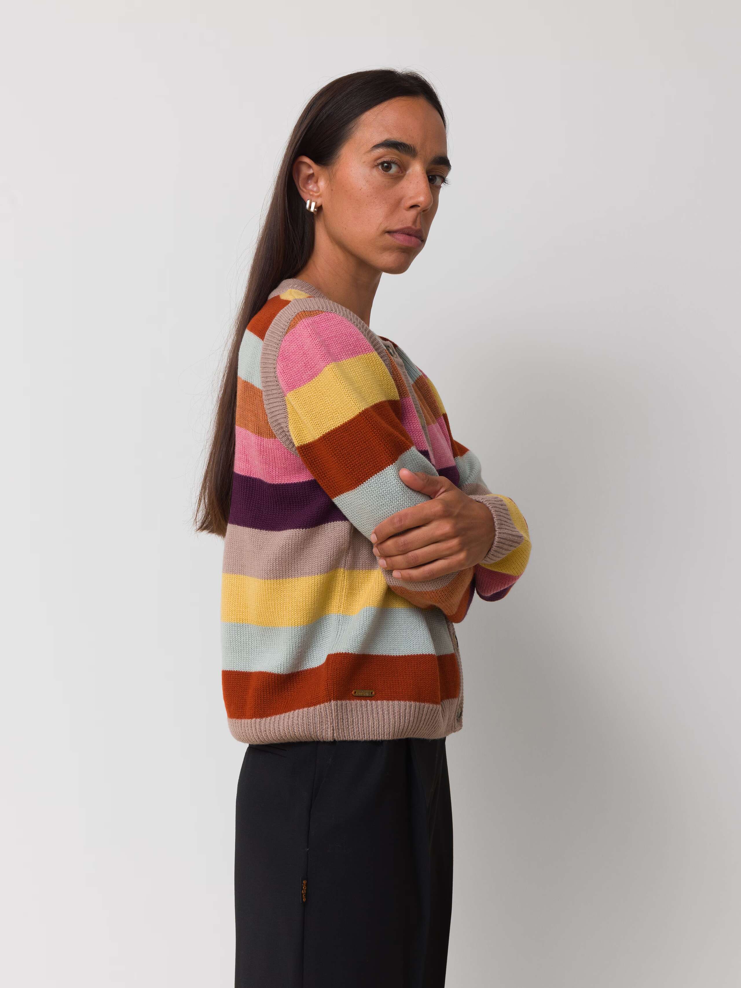 Female model is wearing a colourfully striped merino wool cardigan
