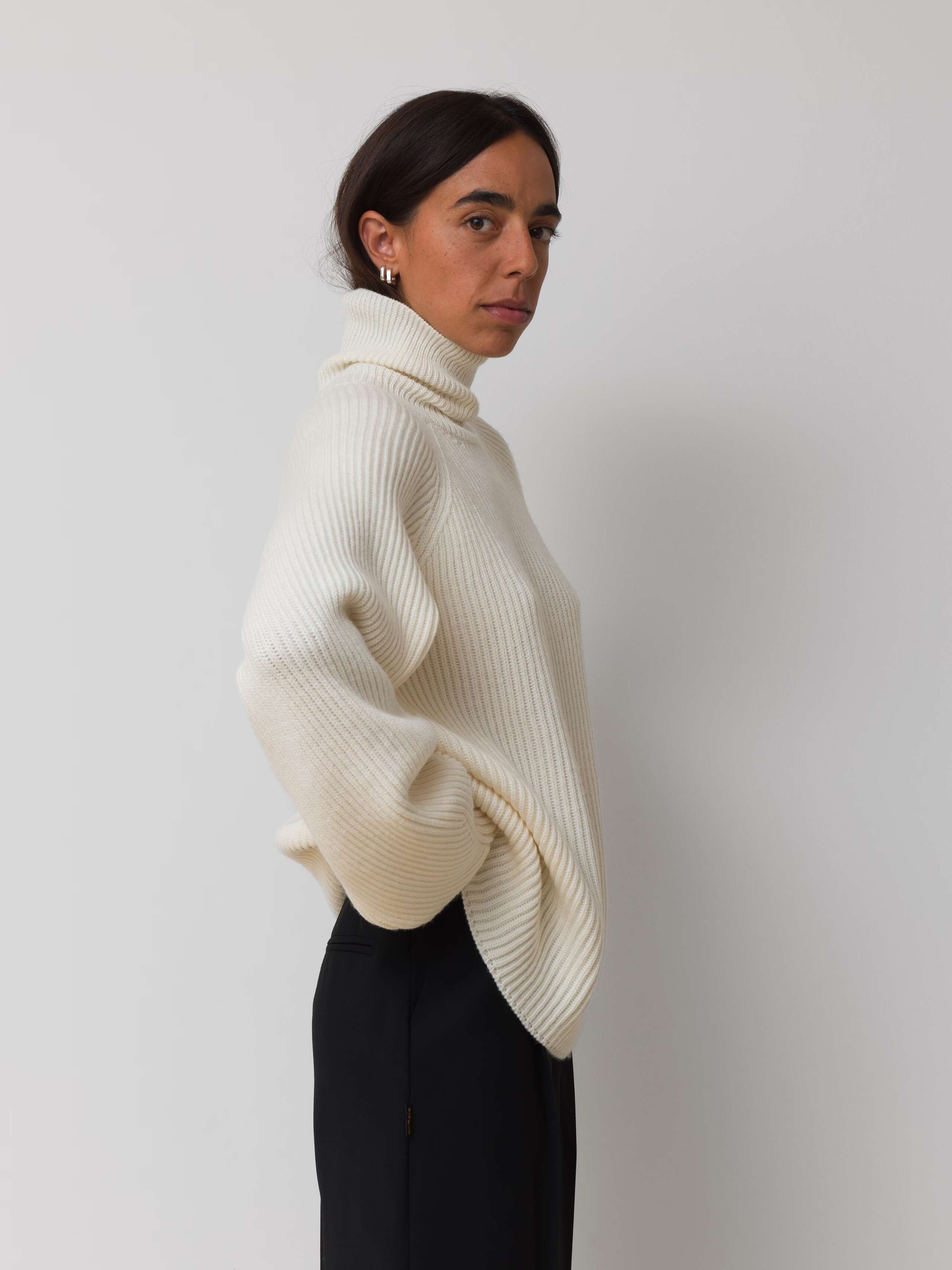 Picture of a female model wearing an off white turtleneck pullover