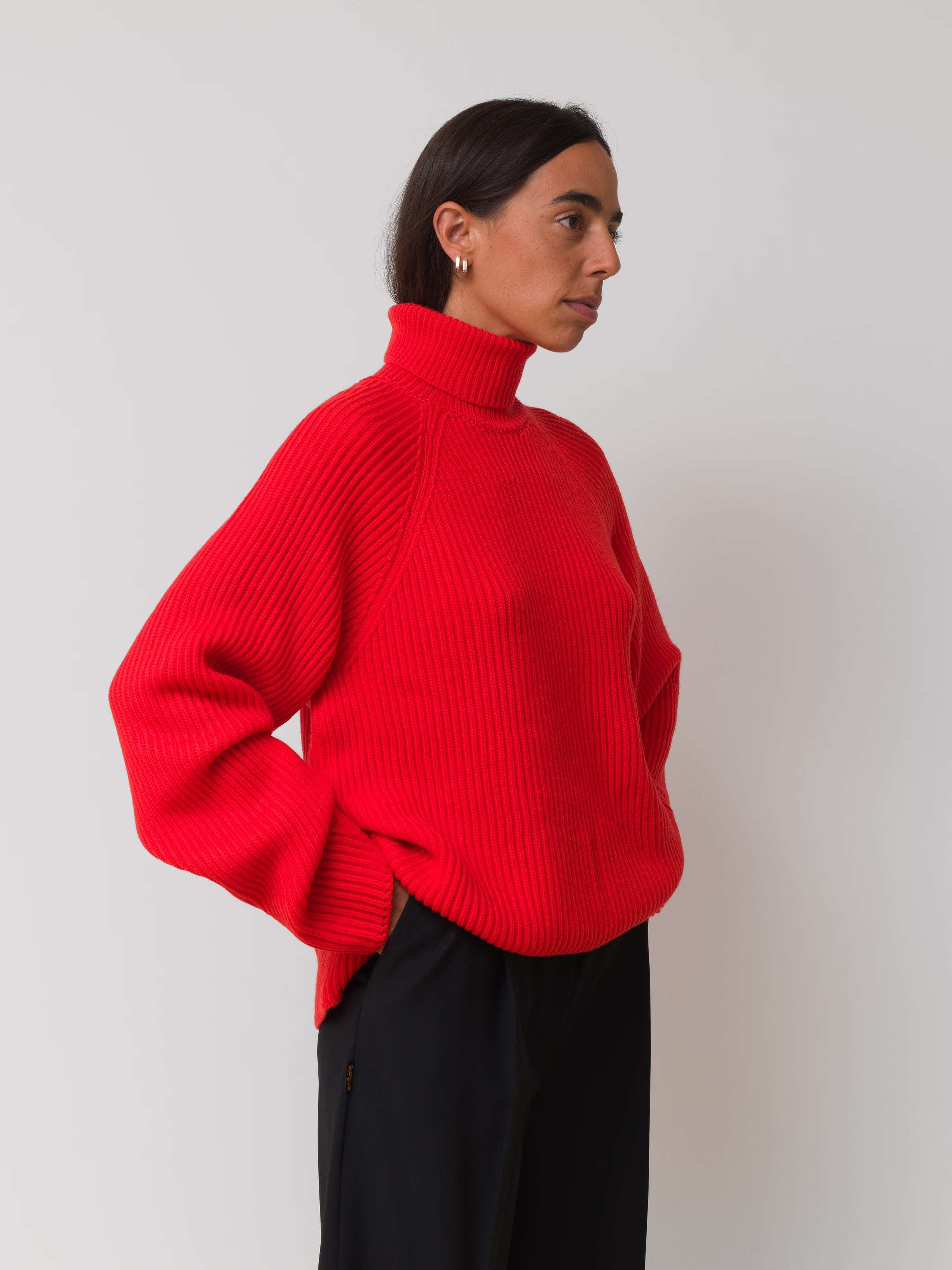 Picture of a female model wearing a red turtleneck pullover