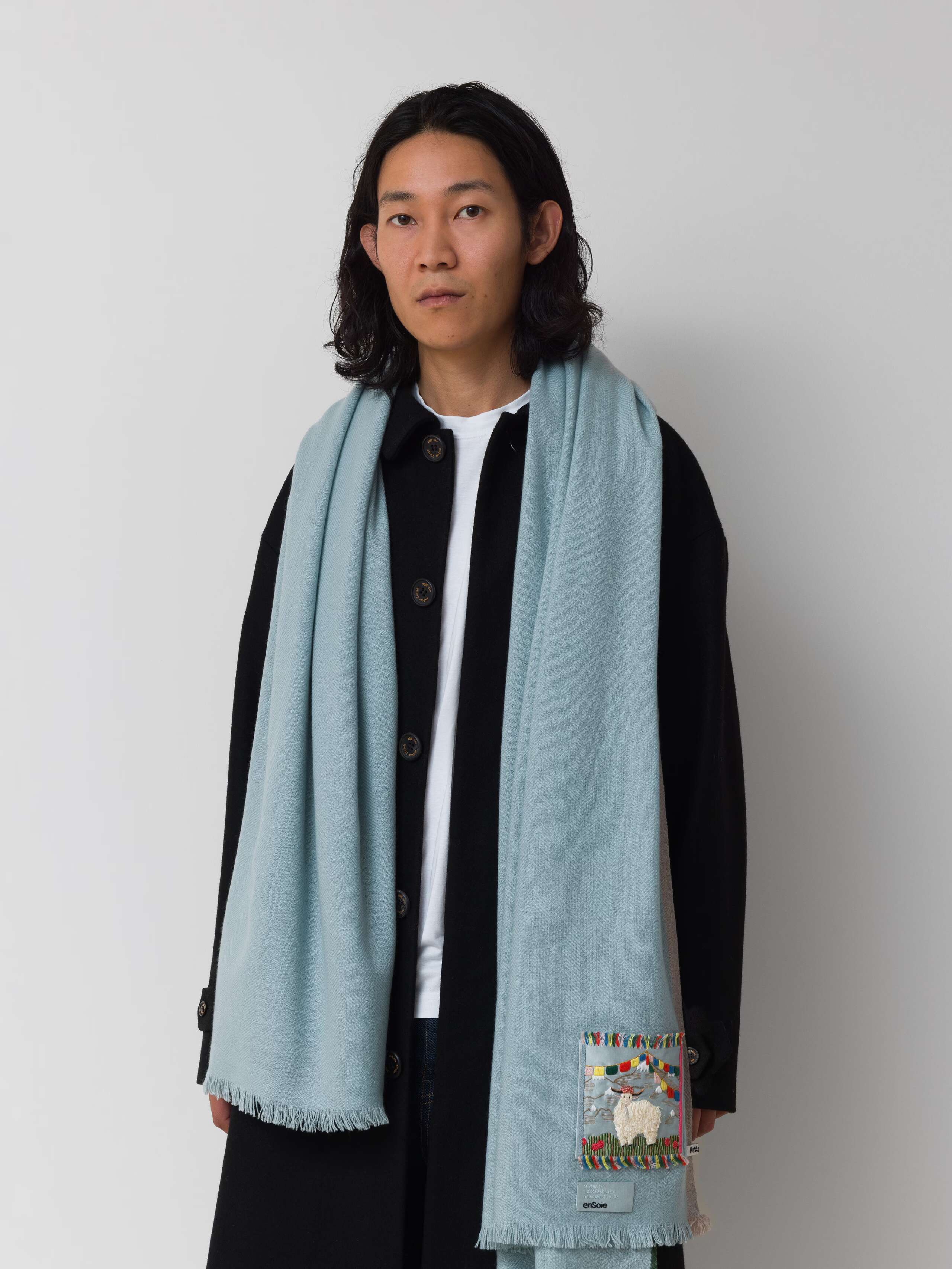 Picture of a male model wearing a light blue scarf