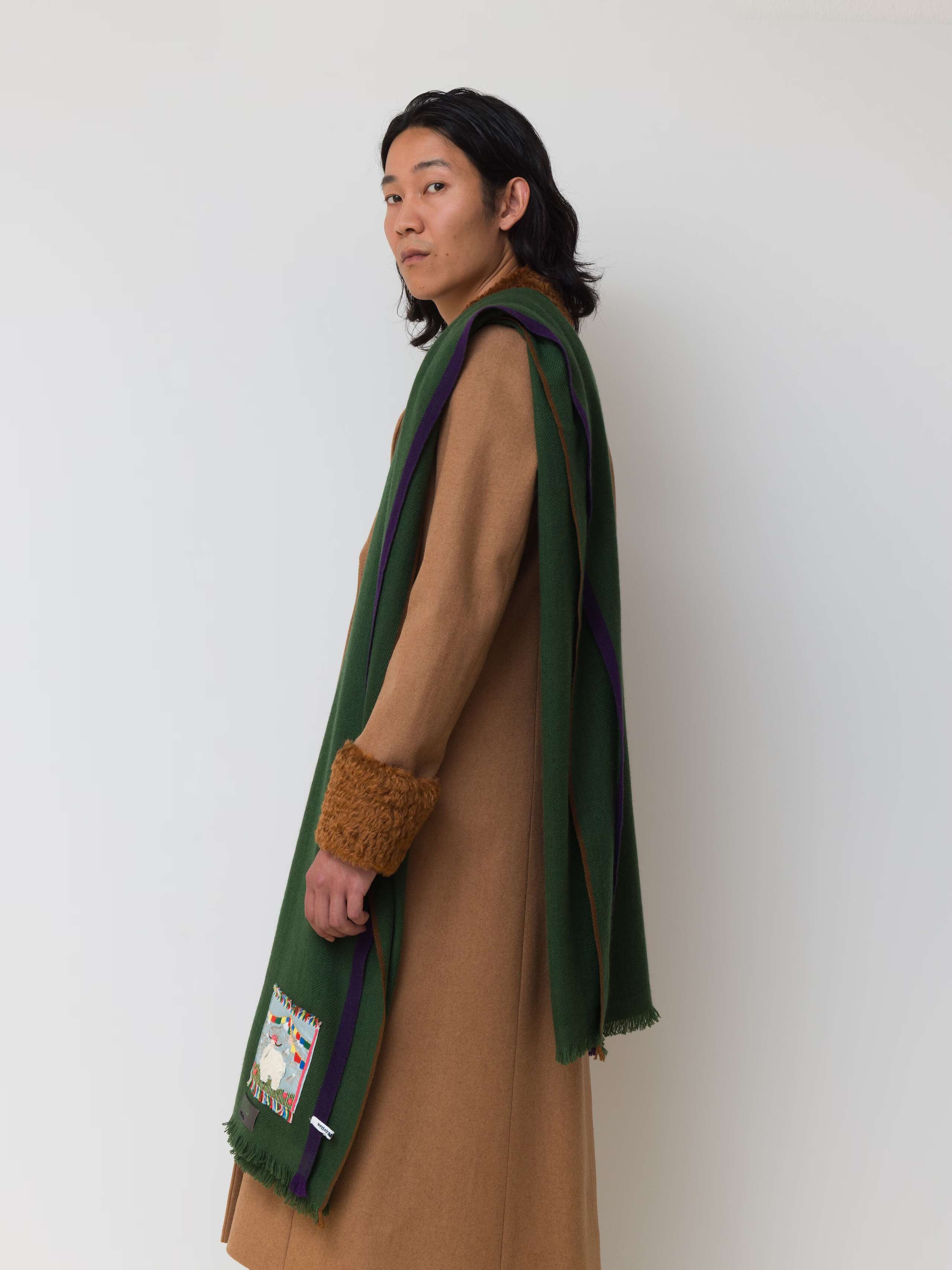 Picture of a male model wearing a dark green cashmere scarf