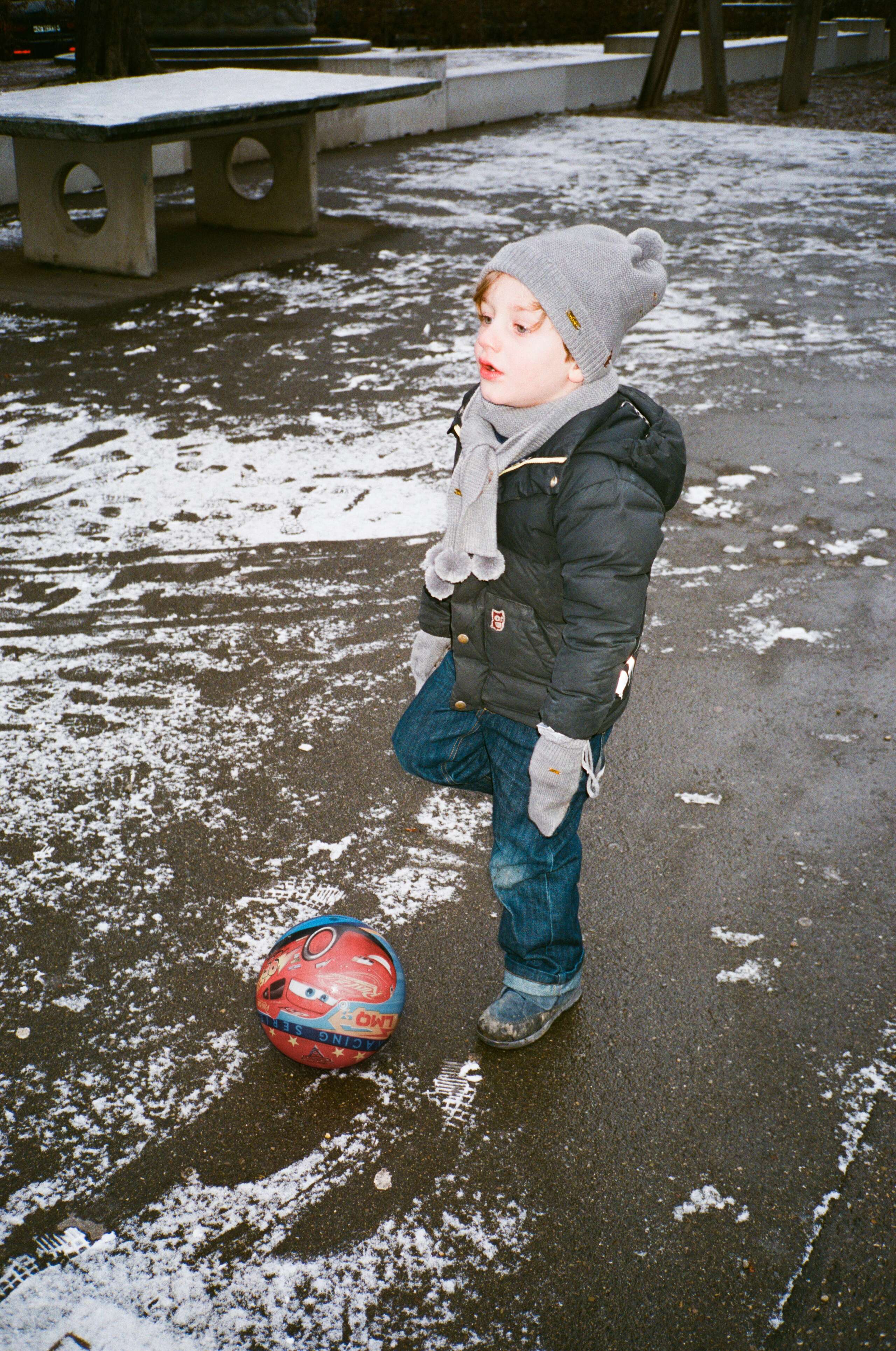 Ciro on Brupbacherplatz playground wearing our knit-collection and the enSoie x namuk down jacket.