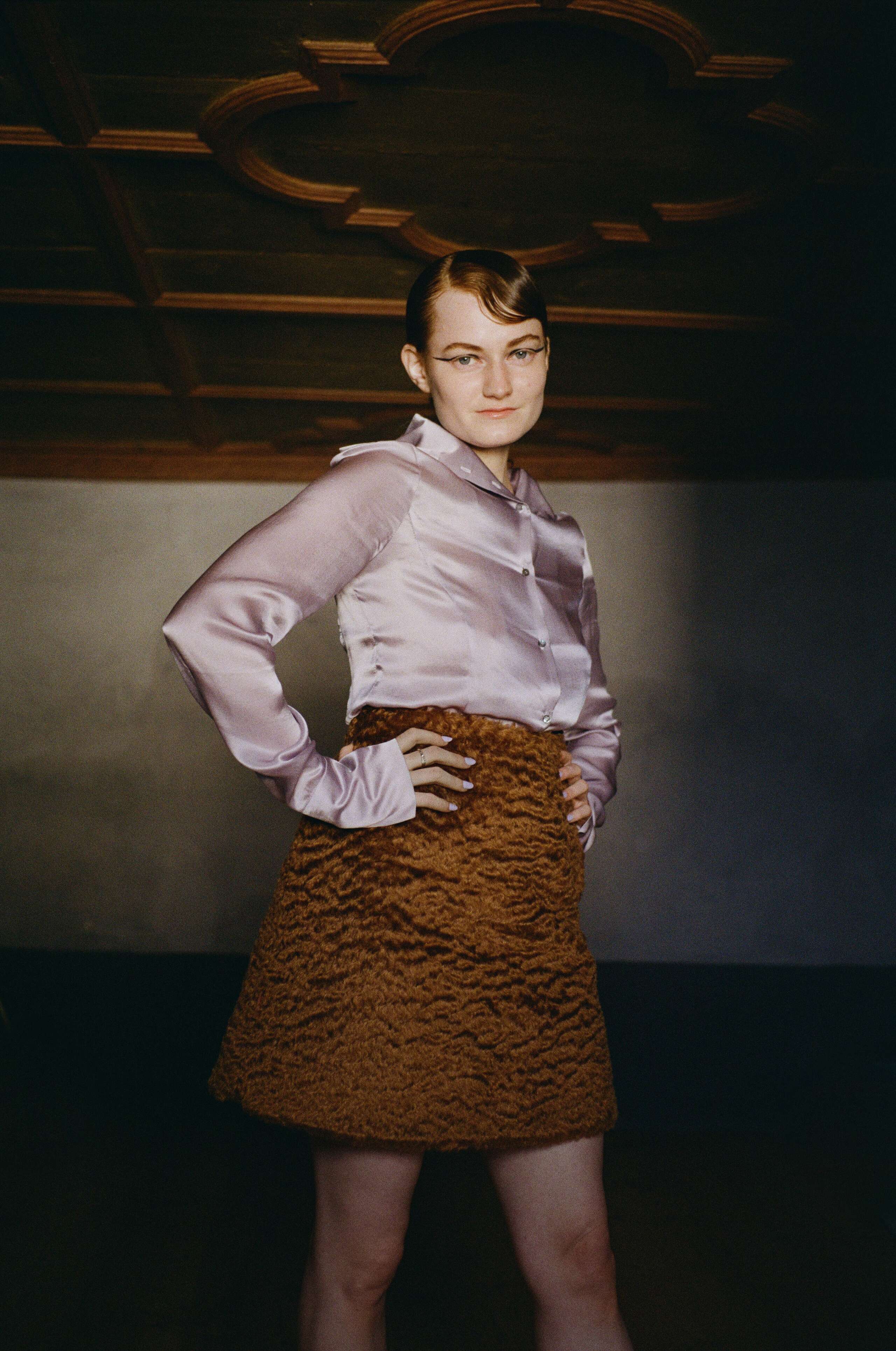 Picture of a female model wearing a soft mohair wool skirt in combination with a shiny silk blouse in lavender